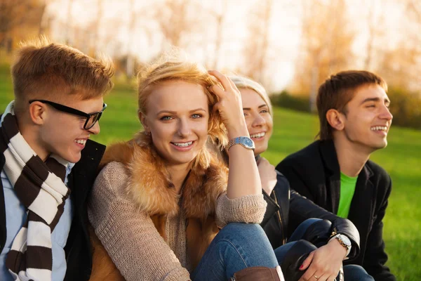 Gelukkig bedrijf zitten in park — Stockfoto