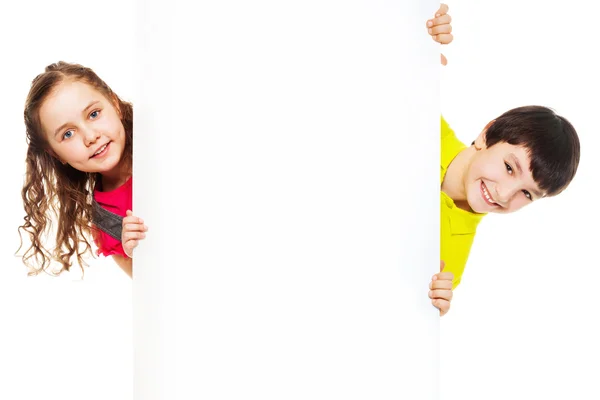 Duas crianças com placa de anúncio em branco — Fotografia de Stock