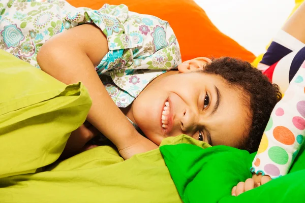 Happy black boy laying on the pillows — Stock Photo, Image