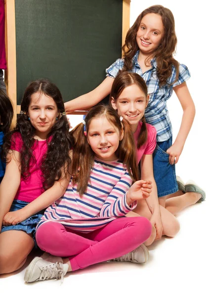 Quatro meninas da escola e quadro negro — Fotografia de Stock