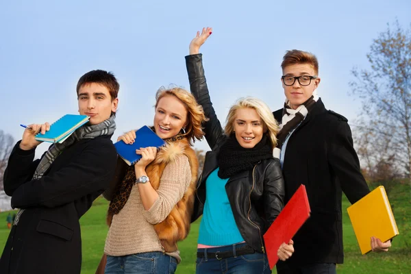 Four students with books cheering — Stock Photo, Image