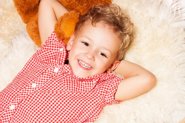 Happy blond kid on the furs — Stock Photo, Image
