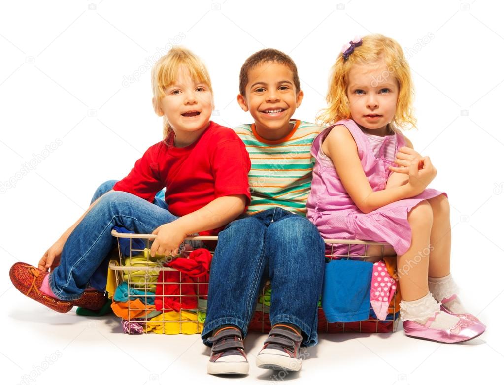three kids sitting in the clothes basket