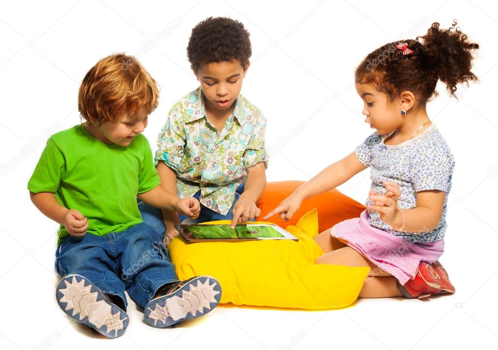 Two boys and girl playing with tablet