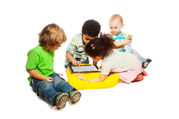 Чотири дитини грають на планшетному комп'ютері — стокове фото