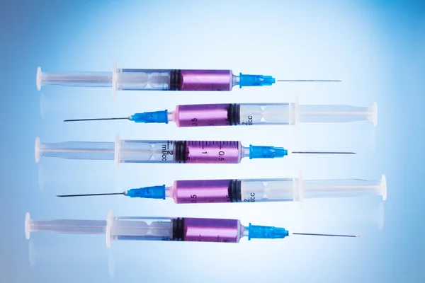 Injections in syringes with pink fluid — Stock Photo, Image