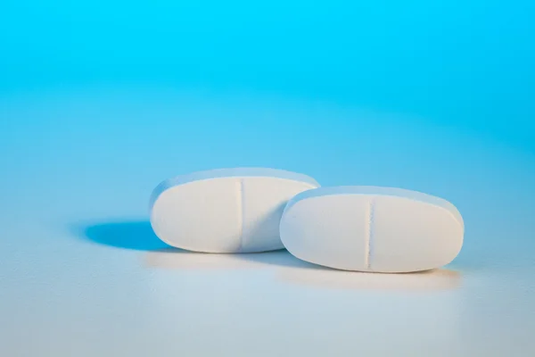 Twee tabletten op blauw — Stockfoto