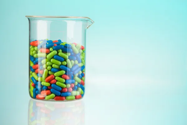 Glass full of color pills — Stock Photo, Image