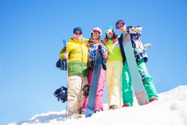 dört mutlu arkadaş sevgiyle sarılmak ve snowboards tutun