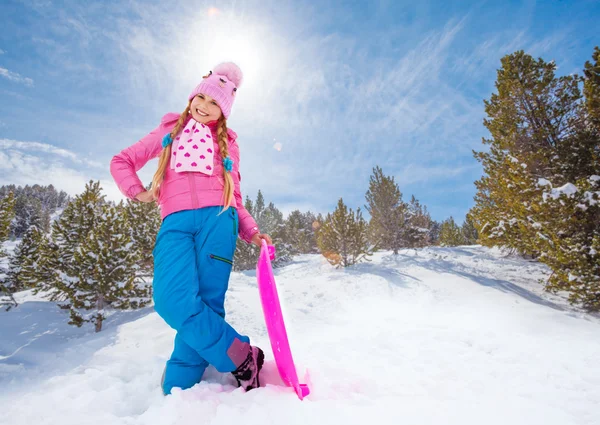 Happy girl in pink standing with sled — Stock Photo, Image