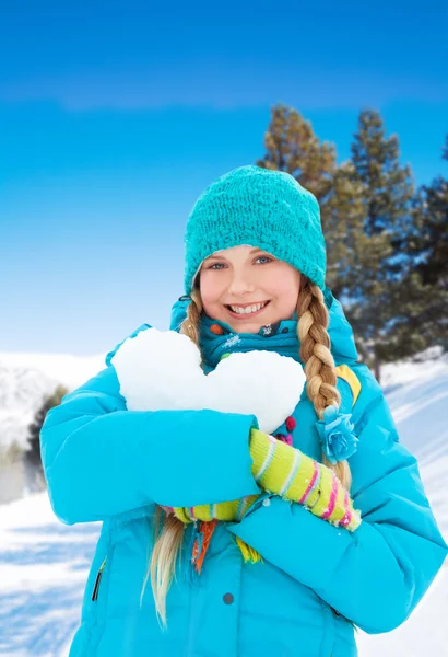 Mooi meisje met hart gemaakt van sneeuw — Stockfoto