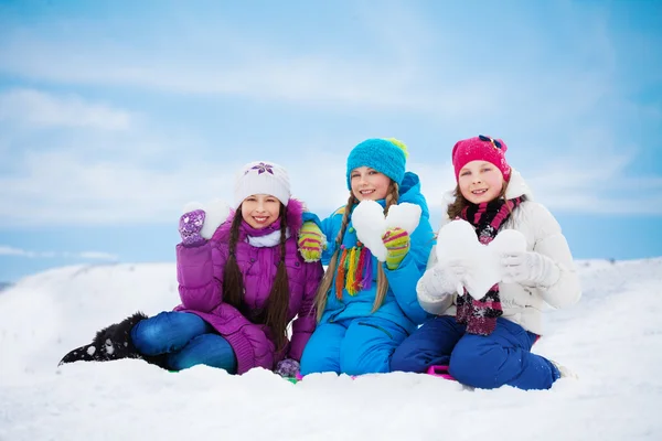 Tres hermosas chicas con corazón hecho de nieve — Foto de Stock