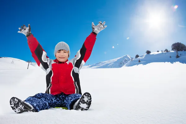 Glücklicher Junge sitzt an sonnigem Tag auf Schlitten — Stockfoto