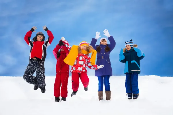 Kids jumping in snow — Stock Photo, Image