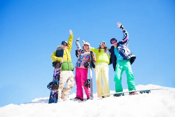 Fyra vänner med snowboards står i snö — Stockfoto