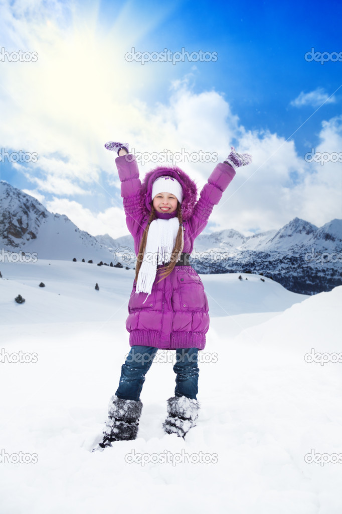 Happy girl with lifted hands on winter day