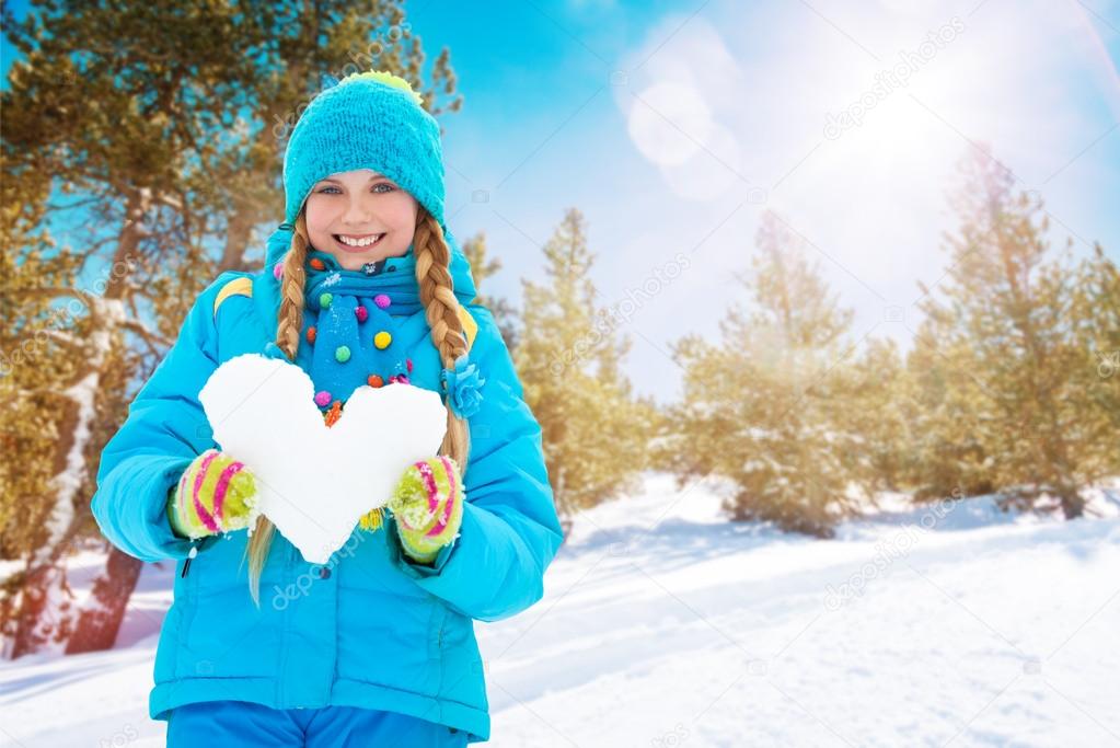 One happy girl with heart made of snow