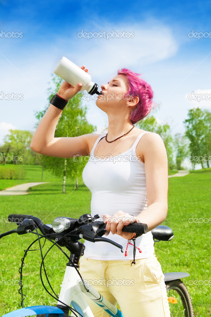 Nice woman biker drinking