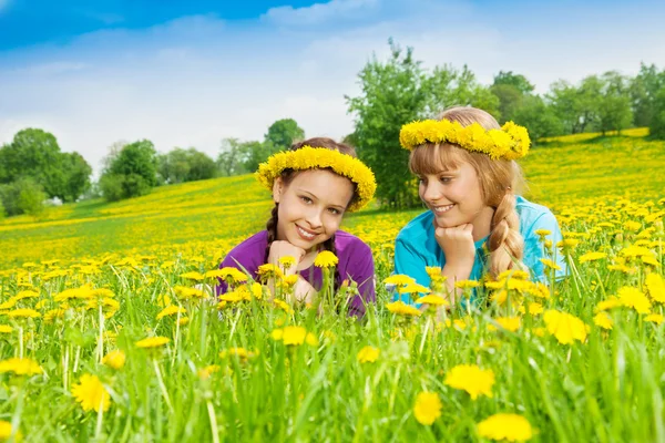 Två leende flickor bär blomma krans — Stockfoto