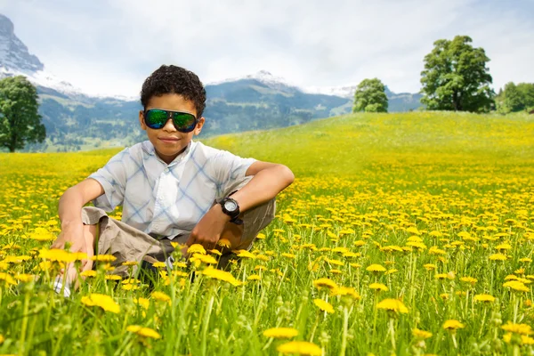 Happy little black sitting boy in sunglasses — Stock Photo, Image