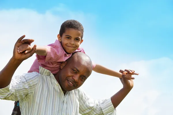 Black boy riding father's shoulders — Stock Photo, Image