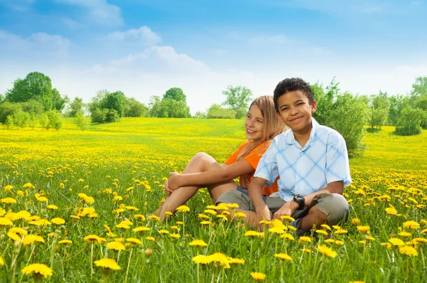 Boy and girl in dandelions — Stock Photo, Image