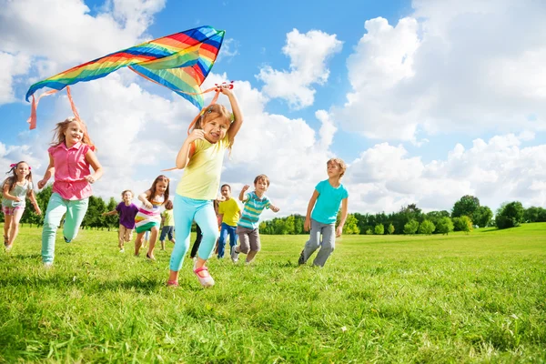 Niedliche Kindergruppe läuft mit Drachen — Stockfoto