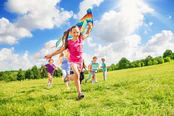 Beautiful girl run with kite together with friends — Stock Photo, Image