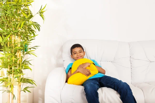 Un felice ragazzo nero sorridente con cuscino — Foto Stock