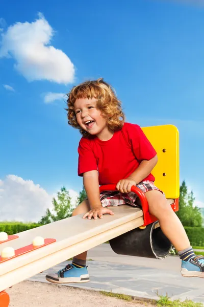 Laughing boy on seesaw — Stock Photo, Image