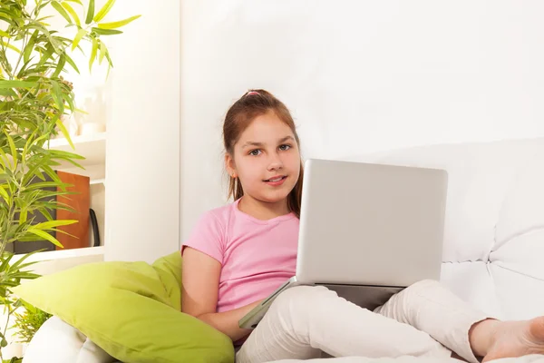 Ragazza con computer portatile seduto sul divano — Foto Stock