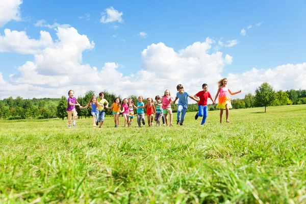 Grande gruppo di bambini che corrono nel parco — Foto Stock