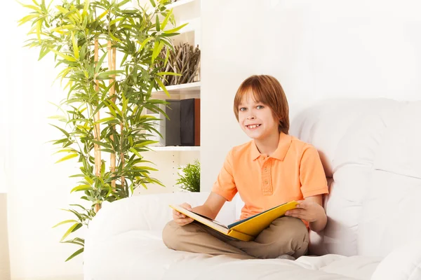 Akıllı çocuğu kanepe üzerinde kitap okuma — Stok fotoğraf