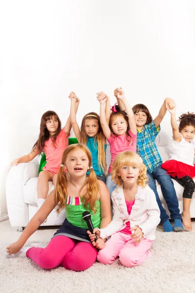 Two girls singing with friends — Stock Photo, Image