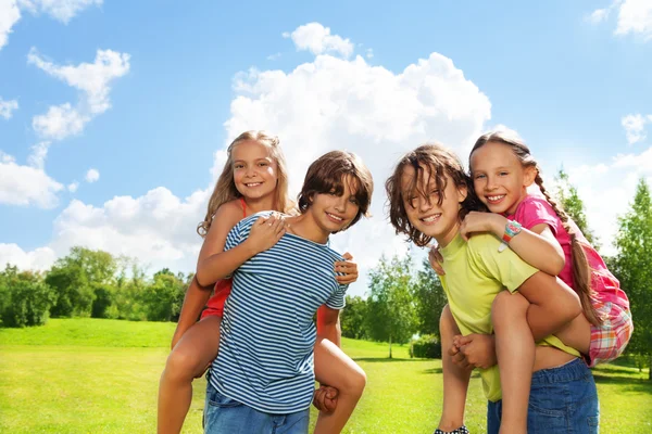 Two couple of kids riding on each other — Stock Photo, Image