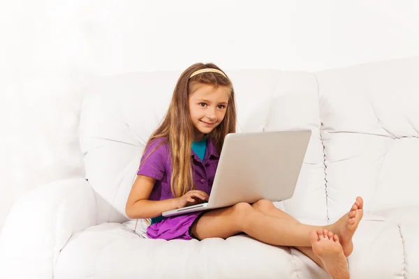 Ragazza con computer portatile sul divano — Foto Stock