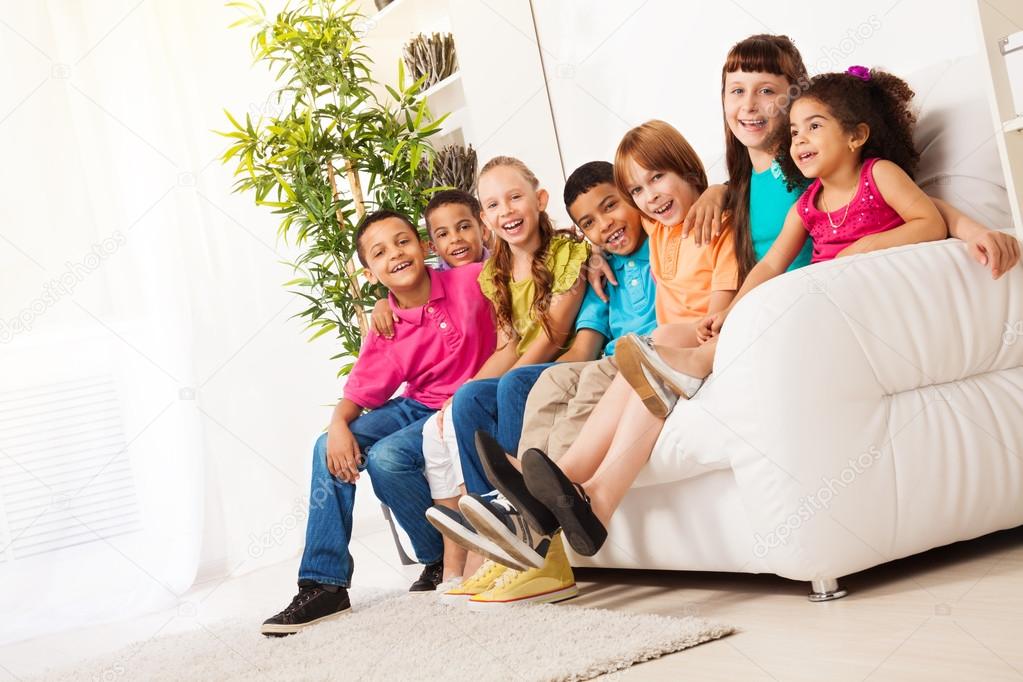 Large group of kids sitting on couch in a row