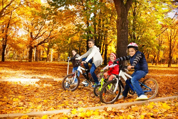 Hermanos y hermanas montando bicicletas — Foto de Stock