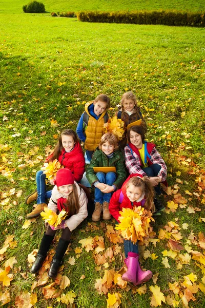 Дети на осенней лужайке — стоковое фото