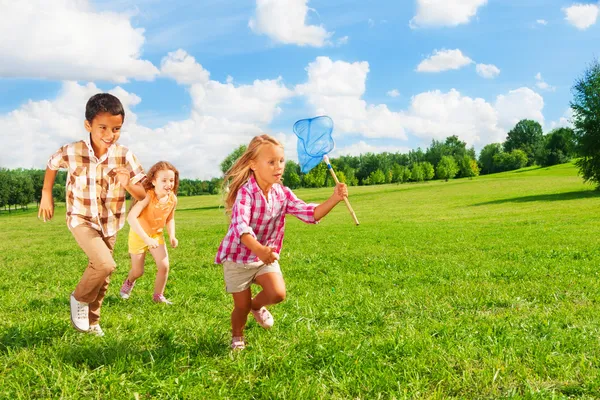 Dzieci biegają z netto motyl — Zdjęcie stockowe