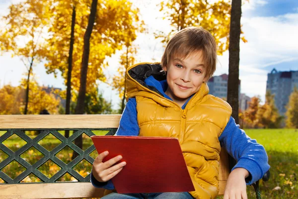 Pojke med papper på bänken — Stockfoto