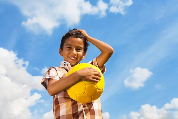 Мальчик с мячом над небом — стоковое фото