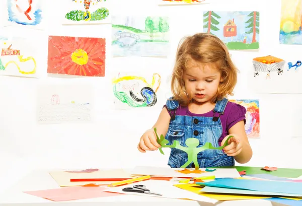 Girl cutting shapes from paper — Stock Photo, Image