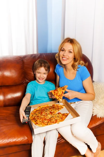 Junge und seine lächelnde Mutter beim Pizza essen — Stockfoto