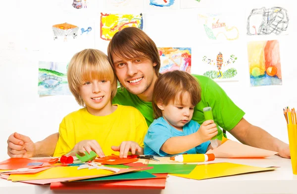 Papà e i suoi bambini tagliano e incollano i mestieri dalla carta — Foto Stock
