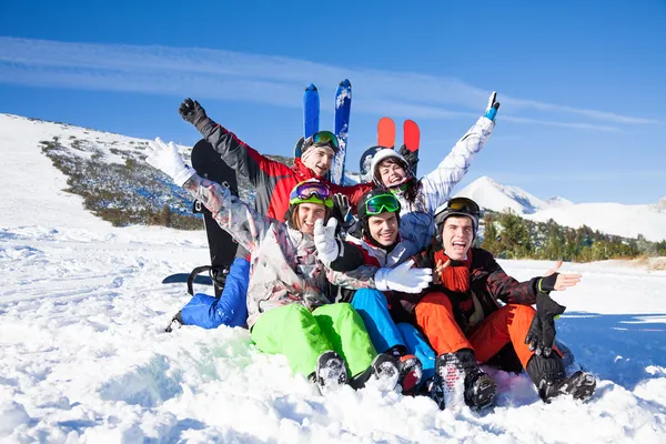 Amigos sentados na neve nas montanhas — Fotografia de Stock