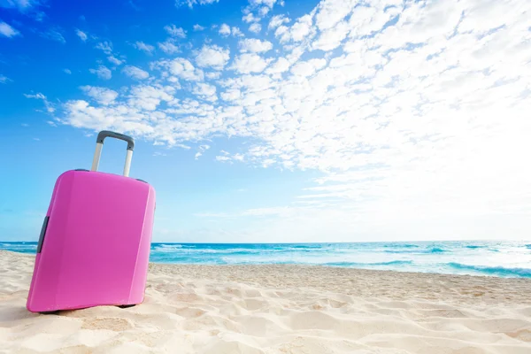 Roze Bagage tas op het strand — Stockfoto