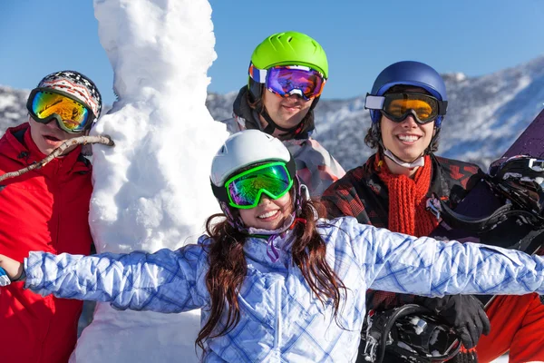 Personas con snowboard y muñeco de nieve —  Fotos de Stock