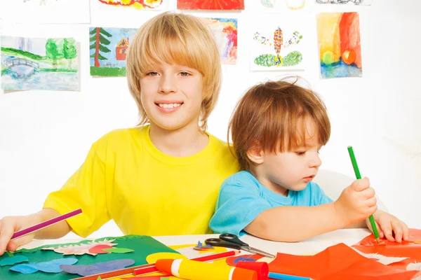 Los niños pequeños dibujan artesanía de corte y pegamento con papel —  Fotos de Stock