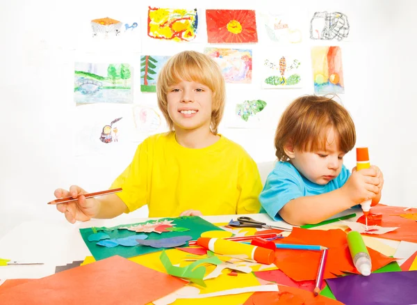 Los niños pequeños dibujan artesanía de corte y pegamento con papel —  Fotos de Stock